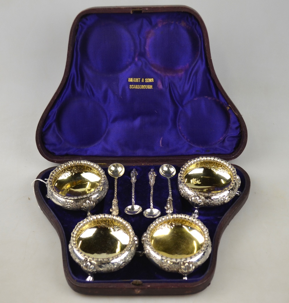 A Victorian cased set of four open silver salts with floral chasing, on hoof feet, Martin,