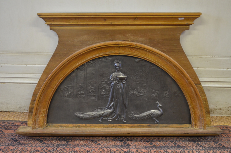An antique pre-raphaelite style cast iron panel of arch form depicting a lady with peacocks in a