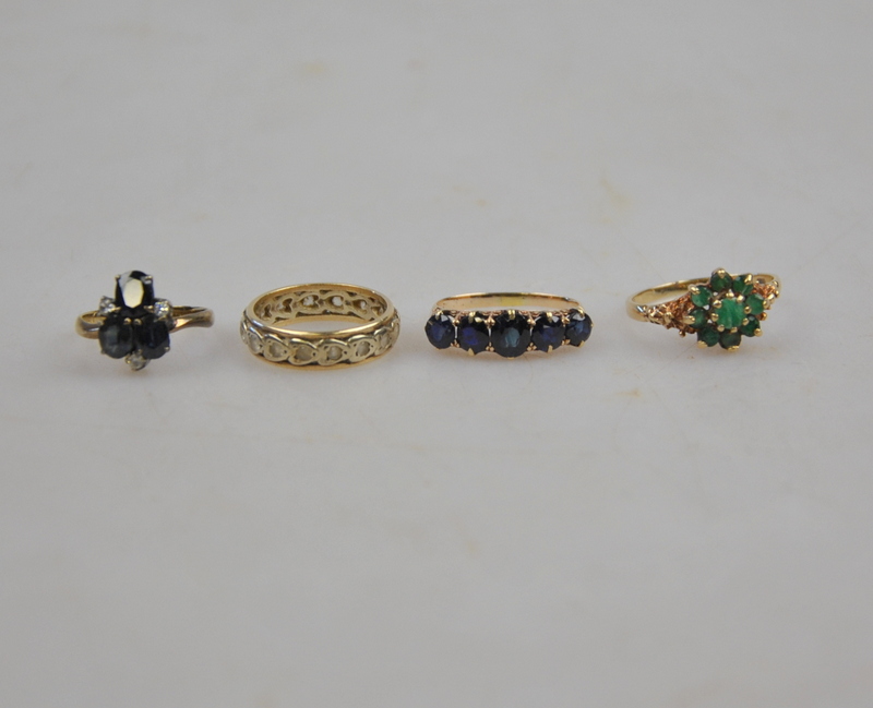 Four dress rings, one 9ct set with emeralds, two set with dark sapphires,