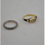 A Victorian yellow gold mourning ring, with black enamelled shoulders each set with seed pearl,