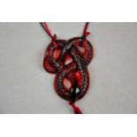 A modern Lalique glass pendant in the form of a coiled serpent in red opalescent glass with red and