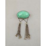 An Arts & Crafts green stone cabochon brooch having two suspended tassels with river pearl