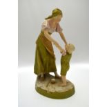 A Royal Dux model of a mother and young son, playing on an oval base, pink pad mark and imp no 1312,