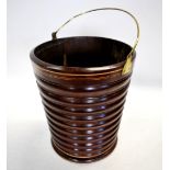 A mahogany peat bucket of ribbed and tapering form with stringing and brass loop handle,