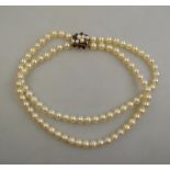 A two row cultured pearl choker of uniform size on 9ct yellow gold garnet and cultured pearl snap,