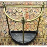 An antique brass demi lune five division stick stand with cast iron base,