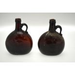 A pair of early 19th century brown glass brandy bottles, each with a strap handle, 18.5 cm h.