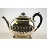 A Victorian silver teapot of oblong form, with chased and embossed decoration, on ball feet, Henry