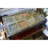 An antique polychrome decorated eight panel door under plate glass top framed as a coffee table,