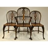 A set of six elm seat wheel-back chairs raised on crinoline stretchers comprising a pair of