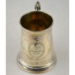 A silver mug of 18th century origin, tapering form with scroll handle,