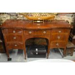 A George III satinwood serpentine front sideboard with central frieze drawer flanked by a nine