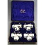 An unusual cased set of three trefoil clover-shaped plate-clips (for petit-fours),