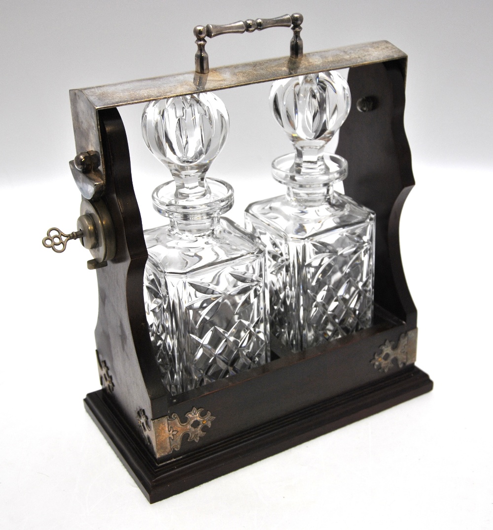 A modern two-bottle tantalus with plated mounts and fitted with square decanters