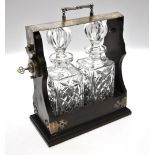 A modern two-bottle tantalus with plated mounts and fitted with square decanters