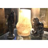 Two Inuit blackstone carvings, Eskimo with caught seal, 15 cm and leaping salmon, 18 cm,