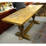 An antique cleated plank top table raised on baluster turned supports to a platform base united by
