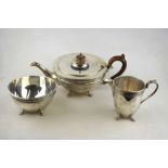 A silver three-piece tea service of hemispherical form with ovoid cream jug, on claw feet,