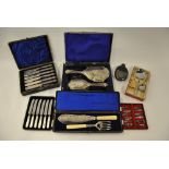 An Edwardian cased set of fish knives and forks with electroplated blades and loaded silver handles,