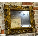 An 18th/19th century Italianate carved giltwood frame with fitted mirror plate,