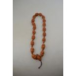 A row of Asian beads carved with various male heads,
