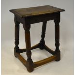 An antique oak joint stool with single plank moulded edge top over a turned frame