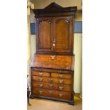 An 18th century oak estate bureau cabinet, probably Scottish, in two parts surmounted by an