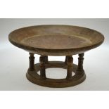A turned wood broad rimmed dish, raised on six pillars and ring foot,