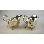 A pair of silver sauce-boats with scroll handles and hoof feet, Hampton Utilities, Birmingham 1966,