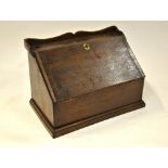 A 19th century oak slope front table top writing cabinet with part fitted interior over a storage