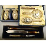 A modern embossed silver five-piece brush set comprising hairbrushes, pair of brushes,