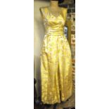 A 1950's ivory silk/yellow floral brocade evening dress, sash to waist and bow-detail to back,