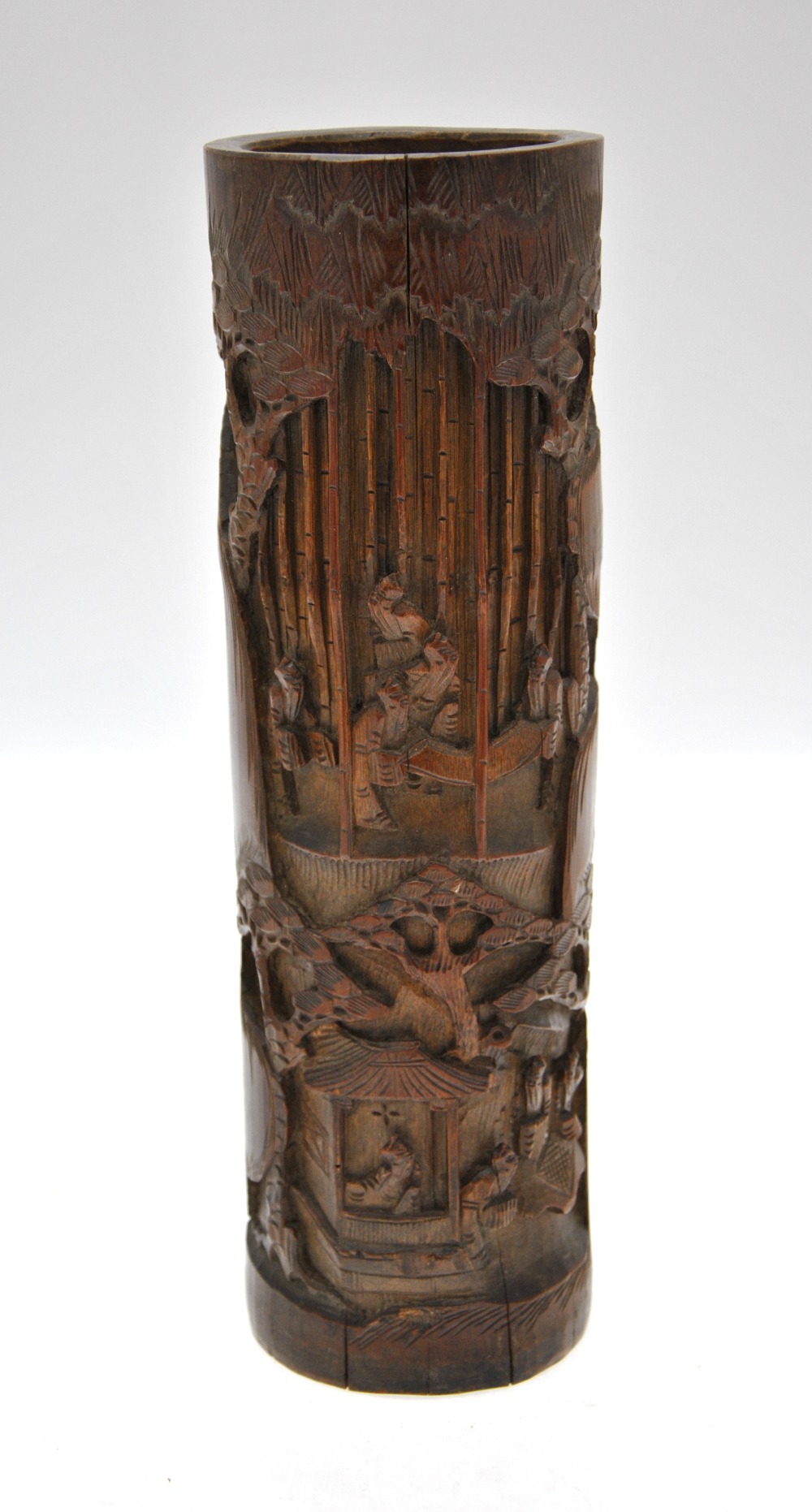 A Chinese bamboo brush pot carved with figures in a forest and figures within and beside a building,