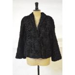 A black Astrakhan box-shaped jacket with bell-shaped sleeves and large button fastening, 58 cm