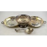 A matched pair of embossed silver wine-dishes with cast scroll handles, London 1913/16,