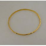 A 1930s engraved yellow metal bangle stamped 22