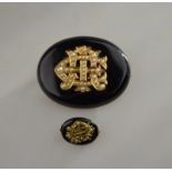 A black onyx brooch with gold pearl set monogram in centre, yellow gold mount, locket at back