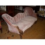 Victorian double-ended couch with carved wood arm ends and supports.