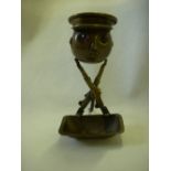 WW1 brass match striker, capped head with glass eyes on crossed rifles to tray base.