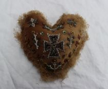 A heart shaped pin cushion with bead wor