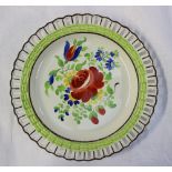 A Swansea pottery ribbon plate painted to the centre with a spray of garden flowers, 21.5cm
