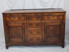 An 18th century North Wales oak dresser base, the planked top above a mahogany frieze and an