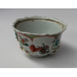 A 19th century Chinese porcelain bowl with a scalloped edge with ogee panels, sprays of garden