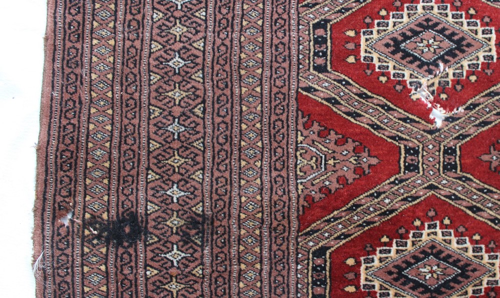 A red ground rug with a central geometri - Image 3 of 6