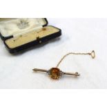 A bar brooch set with a central rectangular citrine, flanked by old cut diamonds to a yellow and