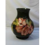 A Moorcroft baluster vase decorated in the Hibiscus pattern to a green ground, Impressed mark,