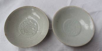 A pair of 18th century Chinese porcelain bowls with a light green glaze decorated with fish in