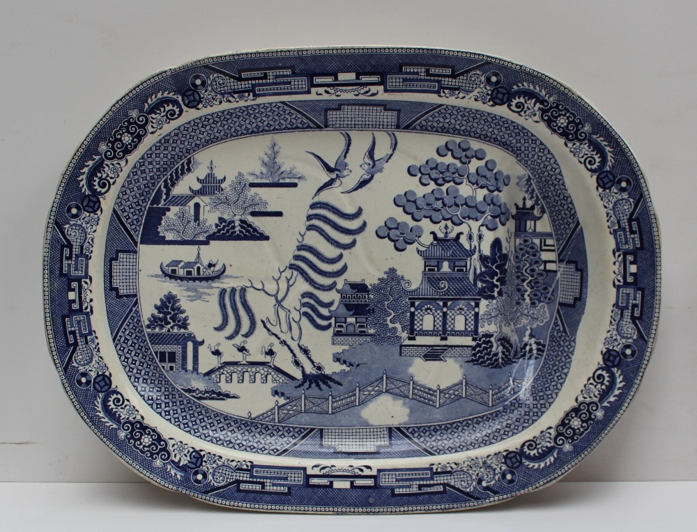 A Baker Bevan & Irwin pottery meat plate, decorated in the willow pattern, with a gravy tree and