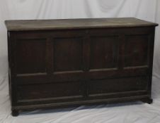 An 18th century oak coffer, the planked rectangular top above a six panelled front on bracket