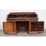 A late Victorian mahogany and walnut roll top desk, the rectangular top with chamfered edge with